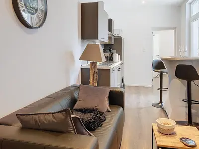 a living room with a leather couch and a table at Angleur Appartement 001 rez arrière in Liège