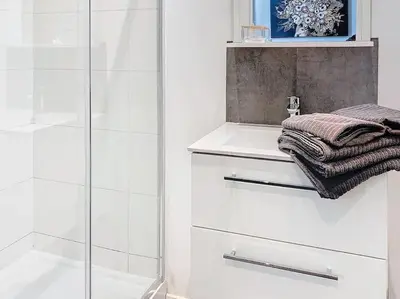 a white bathroom with a shower and a towel at Angleur Appartement 001 rez arrière in Liège