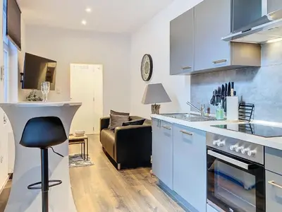 a kitchen with blue cabinets and a couch in a room at Angleur Appartement 001 rez arrière in Liège