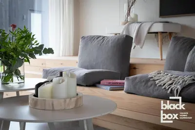 a living room with two couches and a table with candles at Black Box by De Schrijfbar - vakantiewoning Haspengouw in Wellen