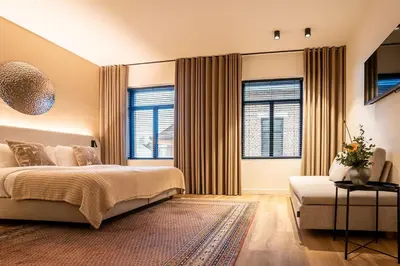 a bedroom with a large bed and two windows at Boutique Hotel Annamaes, Maastricht-Hoge Kempen in Lanaken