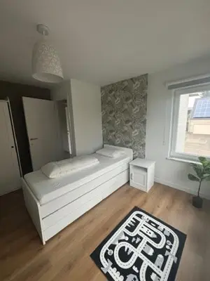 a room with a bed and a window and a rug at La Redoute in Tongeren
