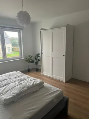 a bedroom with a bed and a cabinet and a window at La Redoute in Tongeren