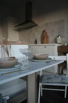 a kitchen with a table with bowls and wine glasses at Casa Lariz in Hasselt