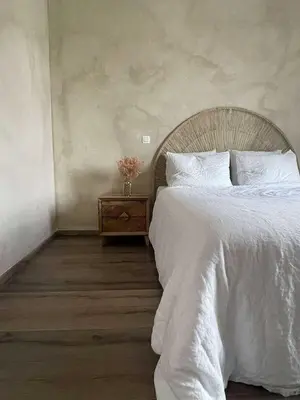 a bedroom with a white bed and a night stand at Casa Lariz in Hasselt