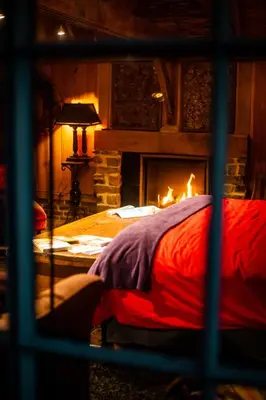 a fireplace in a bedroom with a bed and a fire place at Het Zwart Schaap in Pelt
