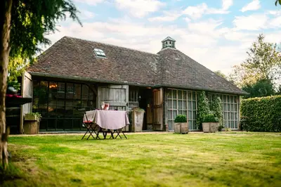 a person sitting at a table in front of a house at Het Zwart Schaap in Pelt