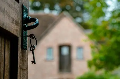a key hanging from a door in front of a house at Het Zwart Schaap in Pelt