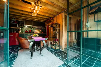 a dining room with a table and a kitchen at Het Zwart Schaap in Pelt