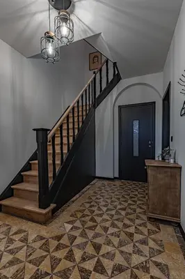 a hallway with a staircase and a black door at Villa Victoire in Heers