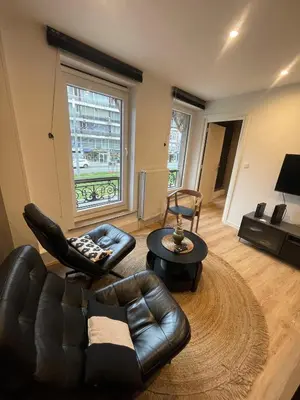 a living room with a leather couch and a table at Magnifique appartement 1 chambre in Liège