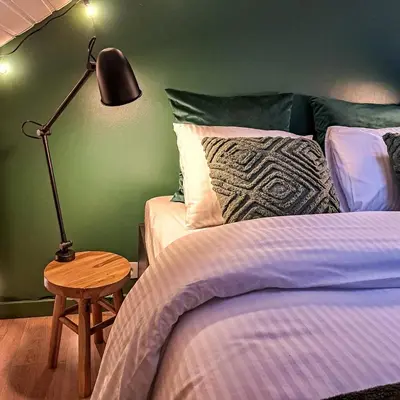 a bedroom with a bed and a lamp on a table at Chambre et salle de bain privative in Liège