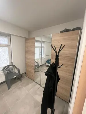 a room with a sliding glass door with a chair at Sterna in Liège