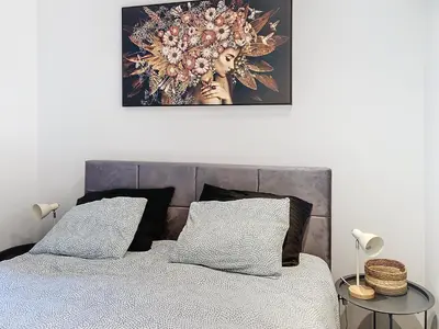 a bedroom with a bed with a picture on the wall at Appartement 002 au rez-de-chaussée avant in Angleur