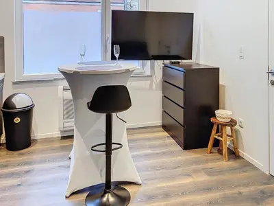a white table with a black stool in a room at Appartement 002 au rez-de-chaussée avant in Angleur