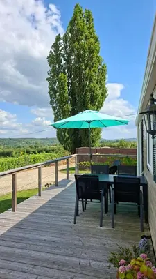 a table and chairs with an umbrella on a deck at Chalet nr 17 Park Bergzicht Teuven in Voeren
