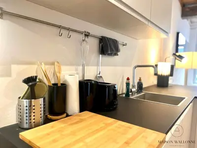 a kitchen with a counter top with a sink and a counter sidx sidx at L'Atelier Triplex - Architect's apartment in Liège