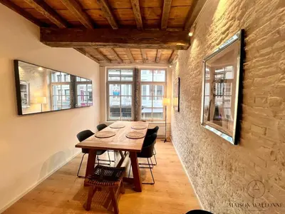 a dining room with a wooden table and chairs at L'Atelier Triplex - Architect's apartment in Liège