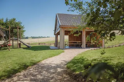 a cabin in a field with a playground at La Bushaye in Aubel
