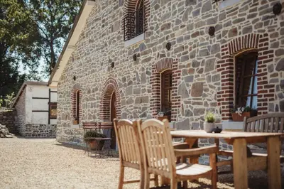 a table and chairs in front of a brick building at La Bushaye in Aubel