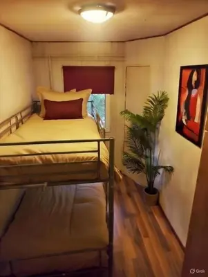 a bedroom with a bed and a potted plant at Chalet Bosrust met serre & privéparking Natuur nabij Maastricht in Lanaken