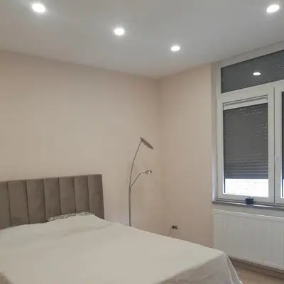 a white bedroom with a bed and a window at RELAX Room in Chaudfontaine