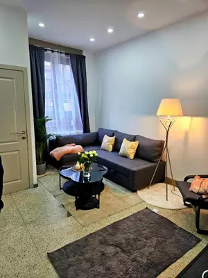 a living room with a blue couch and a table at Jolie petite maison in Liège