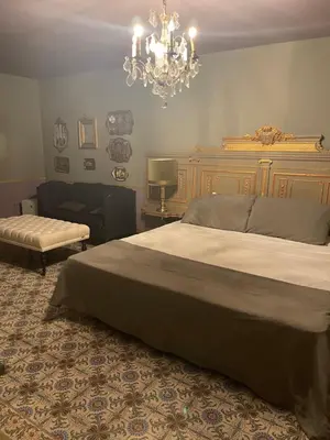 a bedroom with a large bed and a chandelier at Sogni d oro in Peer
