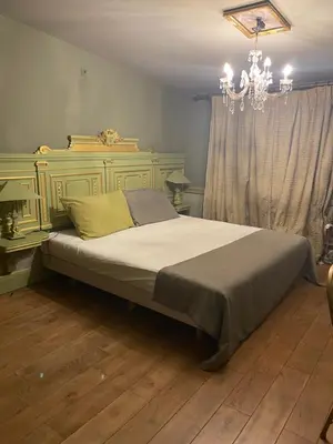 a bedroom with a large bed with a chandelier at Sogni d oro in Peer