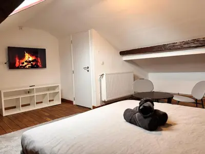 a bedroom with a bed with a fire on the wall at Chambre spacieuse privée avec salle de bain privée in Liège