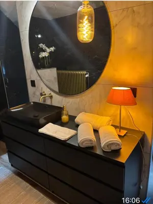 a bathroom with a sink and a lamp and towels at Sophia Rooms 14 in Maasmechelen
