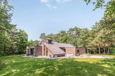 a brick house in the middle of a yard at Ardilla - holiday house in an oasis of green in Heusden - Zolder