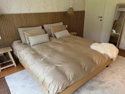 a large bed with white sheets and pillows on it at Ardilla - holiday house in an oasis of green in Heusden - Zolder