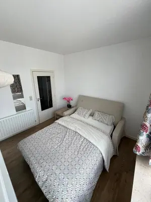a white bedroom with a large bed in it at Phocas in Liège