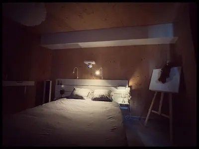 a bedroom with a large bed with a light above it at Appartement tout eco-confort proche du centre in Liège