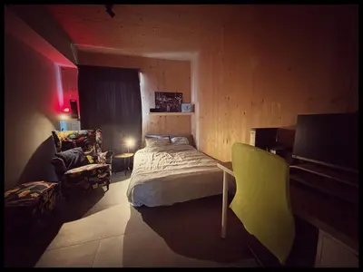 a bedroom with a bed and a chair in it at Appartement tout eco-confort proche du centre in Liège