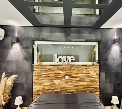 a bedroom with a love sign on a brick wall at Loft de Waroux in Awans