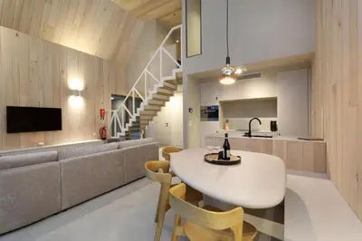 a kitchen and living room with a table and a couch at Lodge - 4 personen - Woodz Lodges in Heusden - Zolder