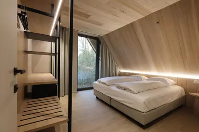 a bedroom with a bed and a large window at Lodge met Jacuzzi - 4 personen - Woodz Lodges in Heusden - Zolder