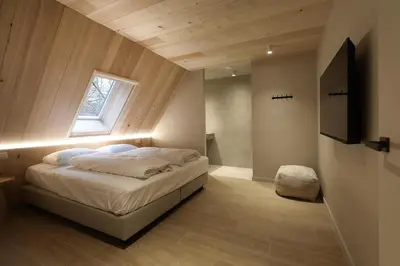 a bedroom with a bed with a window and a television at Lodge met Jacuzzi - 4 personen - Woodz Lodges in Heusden - Zolder