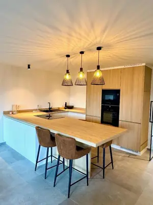 a kitchen with a large wooden table and chairs at Hartje Borgloon in Borgloon