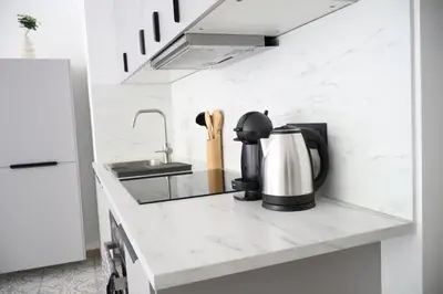 a kitchen counter with a coffee maker and a sink at Le Carlton in Liège