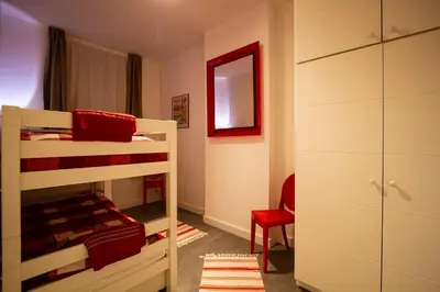 a bedroom with two bunk beds and a red chair at 
