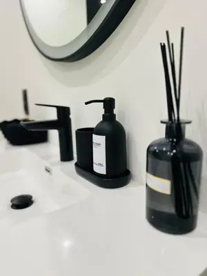 a bathroom counter with two bottles of soap and a mirror at Élégant appartement avec bain balnéothérapie in Liège