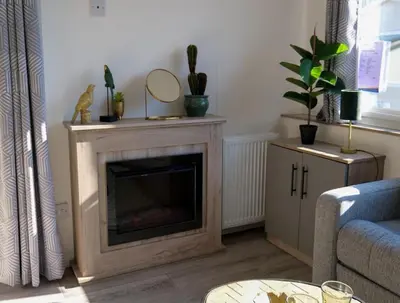 a living room with a fireplace with a mirror on it at Camping Zavelbos Superior Chalet in Maaseik