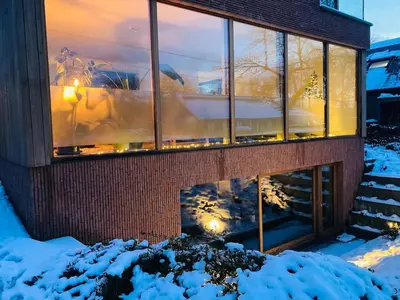 a reflection of a building in the snow at Sweet Valley Cozy in Zutendaal
