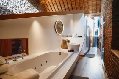 a bathroom with a large tub and a sink at Art'lette Loft Balneo Bath & Infrared Sauna in Herve