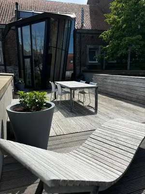 a patio with a table and a bench on a deck at Art'lette Loft Balneo Bath & Infrared Sauna in Herve