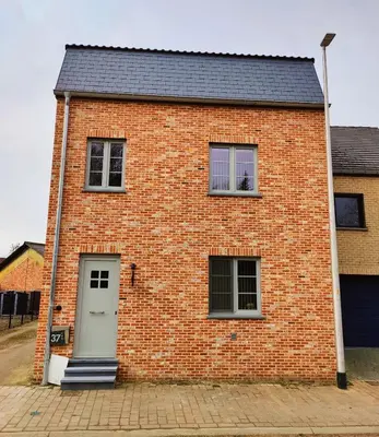 a brick building with a door and two windows at Princenhuis37 in Tongeren