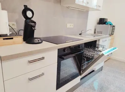 a kitchen with an oven with a sink and a clock at Princenhuis37 in Tongeren